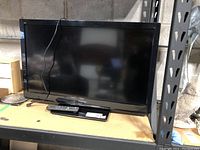 Front view of the Panasonic 37 inch flat screen TV on a shelf with cables visible.
