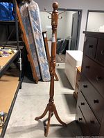 Full view of the pine wood coat rack showing the tripod base and overall height.