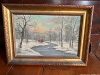 Full view of framed winter landscape oil painting showing snow, trees, and river under a soft sky.