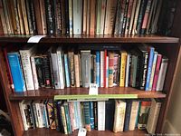 Books on a shelf showing a variety of history, politics, literature titles including Edgar Allan Poe and memoirs.