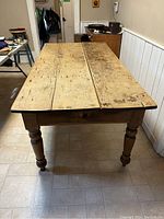 Full front view showing plank surface and turned legs