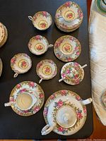 Full view of 6 teacups, saucers, sugar bowl, and one plate showing Tapestry Rose floral pattern
