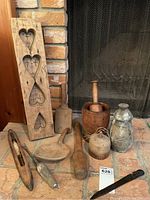 Multiple carved wood utensils and vessels arranged on brick hearth