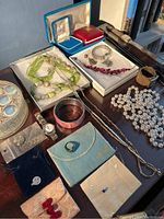 Overview of all items: multiple necklaces, bracelets, bangles, watches, jewelry boxes, pouches, earrings on wooden surface