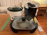 Oster electric skillet with glass lid in front, Rival Crock-Pot slow cooker and Keurig coffee maker in background