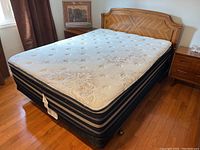 Full view of queen bed set with headboard, mattress, box spring and frame