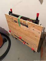 Folded view of Black & Decker Workmate 425 with wooden worktop showing clamp handles and frame underneath