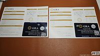 Two GRA certification reports and certification cards for two moissanite stones, showing grading details including VVS1 clarity and D color, 1 carat each.