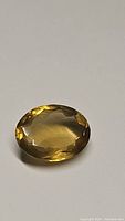 Close-up front view of 12ct oval cut golden champagne citrine gemstone showing color and clarity.
