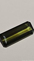 Close-up photo of the natural untreated green tourmaline showing its octagon cut and rich green color.