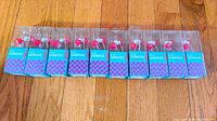 Front view of 10 new Kikkerland Ruby Earbuds in original turquoise and pink packaging, showing the ruby decoration on each earbud.