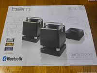 Front view of the sealed Bem Wireless Bluetooth Party Blocks box showing the image of two cube-shaped speakers and a Bluetooth transmitter with product details such as multi color mode and Bluetooth logo.