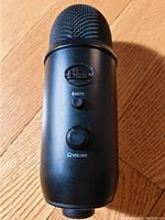 Front of Blue Microphone showing mute and volume controls on black matte metal body.