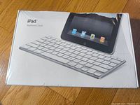 Sealed Apple iPad Keyboard Dock in original box showing front image of the keyboard dock and iPad illustration.