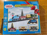 Front of the box showing the complete Thomas and Friends Christmas Deluxe train set with train and track illustrated.