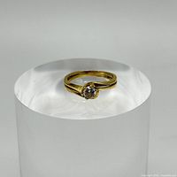 front view showing solitaire round stone in six-prong setting on yellow gold bypass band