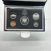 Top view of five coins arranged in black presentation case, highlighting reverse designs.