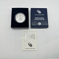 Photo of the silver coin inside United States Mint box with certificate of authenticity shown.