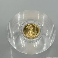 Obverse of 2013 American Eagle one-tenth ounce gold proof coin in clear capsule on acrylic block