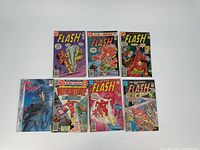 Seven vintage comics grouped showing front covers, six for The Flash and one Iron Marshal.