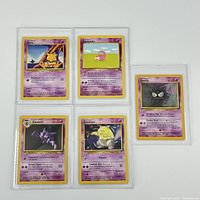 Five Pokémon cards including Abra, Slowpoke, Gastly, Haunter, and Drowzee in protective sleeves.