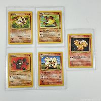 Five Pokémon cards displayed on a white background in protective sleeves: Mankey, Primeape, Geodude, Arcanine, and holographic Vulpix.