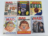 Six Mad Magazine issues from mostly the 1980s and 1990s with varying satirical covers including Alfred E. Neuman and The Addams Family.