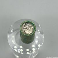 Top view of dime roll showing Roosevelt head visible on top coin wrapped in green Harrah's paper.