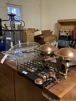 Wide shot of chandelier, acrylic containers, chafing dishes and burner frame on wooden table