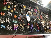 Overview of assorted chunky jewelry on black marble surface