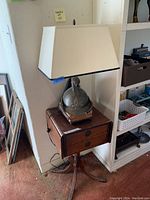 Full view of wooden table with lamp on top showing overall setup.