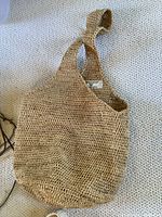 Single wide strap woven raffia bag on carpet