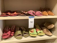 Front view of two shelves of ladies shoes showing multiple styles and colors including pink, green, orange, and beige shoes