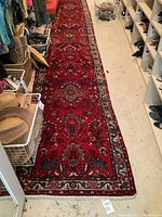 Full‐length view of red floral runner rug laid in narrow hallway