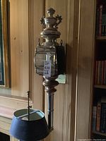 Full view of one sconce unlit against wood panel wall