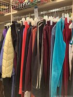 Wide view of hanging velour jogging suits in various colors on white hangers
