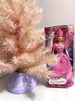 Pink Barbie Swan Lake tree with purple base labeled 'Barbie Swan Lake', about 2 feet tall, next to boxed Barbie doll 'Corinne' from 2008 movie 'Barbie and The Three Musketeers'