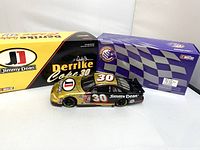 Photo showing the diecast car outside of packaging with two boxes behind, one yellow Jimmy Dean box and one blue checkered flag box