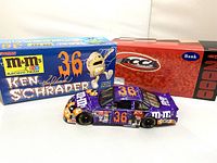 Front and side view showing the purple #36 Ken Schrader M&M's racing stock car with original packaging behind it.