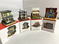Four miniature buildings displayed on top of original boxes showing building names and artwork.
