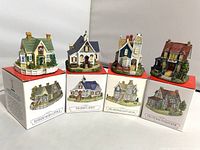 Four Liberty Falls miniature village buildings displayed on top of their original boxes with name and illustration visible on the boxes.
