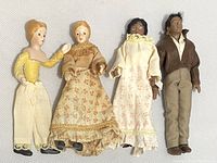 Four vintage miniature dolls with porcelain heads and stuffed fabric bodies laid side by side showing overall collection.