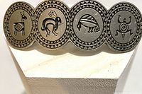 Top front view showing four round medallions with etched Southwest Native American symbols.