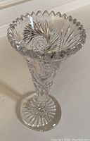 Front angle view of Bohemian crystal vase showing notched rim and cut pattern details.