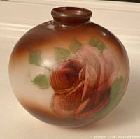 Front side of the globe-shaped vase showing detailed painted rose and leaves with brown and cream gradient background.