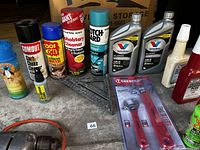 Front view showing various car cleaning aerosol sprays, motor oils, and a vintage drill. Also visible are new Crescent adjustable wrenches in packaging.