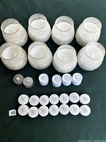 Top-down view of the entire candle set showing 8 wax candles in textured glass holders, 2 silver glitter battery operated candles, and 9 white battery operated tea light candles.