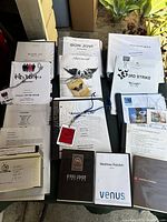 Wide view of stacked production books and binders from various artists including Kid Rock, Aerosmith, Madonna, Blink 182, Bon Jovi, and 3rd Strike.