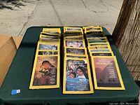 View of 22 National Geographic magazines from 1980-85 collection with various cover images spread on table.