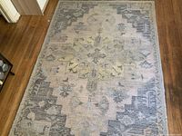 Full view of the 4'x7' Oriental area rug showing central medallion and border design on hardwood floor.